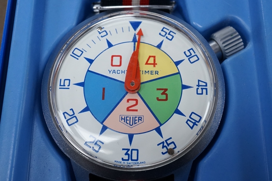 A 1970's steel cased Heuer Yacht Timer wrist stop watch, with polychrome dial, on a fabric strap, case diameter 52mm, with original Heuer tin box.